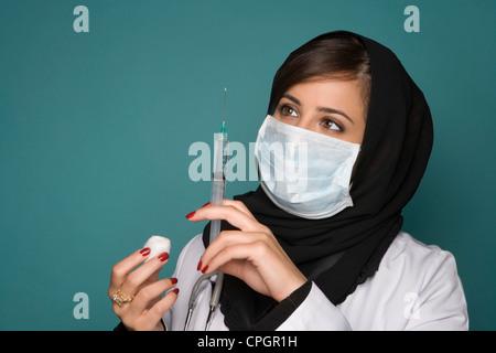 Femme médecin avec un masque chirurgical et de seringues Banque D'Images