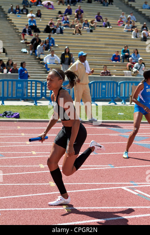 Le sprinteur américain Allyson Felix avec baton dans la main s'exécutant dans une course de relais sur un circuit de champ et rencontrez dans Drake Stadium UCLA Banque D'Images