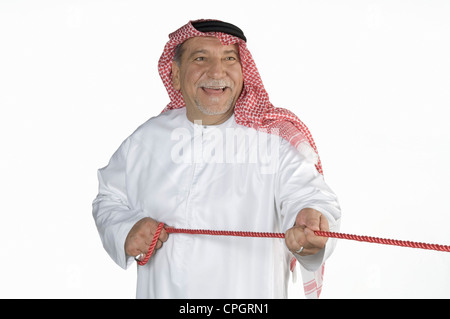 Mature man holding rope, smiling Banque D'Images