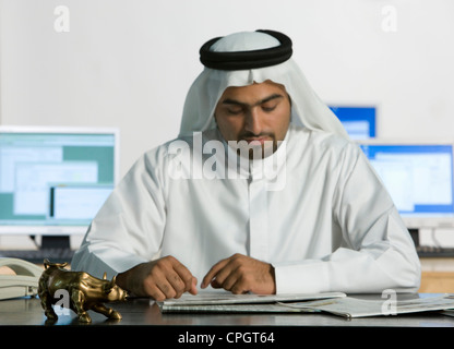 Arab man reading newspaper Banque D'Images