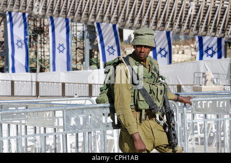 Soldat israélien au garde barrière sur Memorial Day avec des drapeaux israéliens en arrière-plan. Mur ouest. Vieille ville de Jérusalem. Israël. Banque D'Images