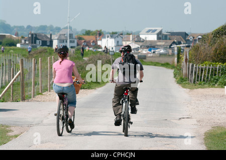 Jeune couple Riding Bikes Cycles les le long d'une piste cyclable Banque D'Images