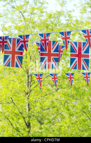 Union Jack flag bunting en face du soleil, arbres Banque D'Images