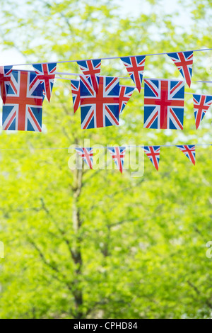 Union Jack flag bunting en face du soleil, arbres Banque D'Images