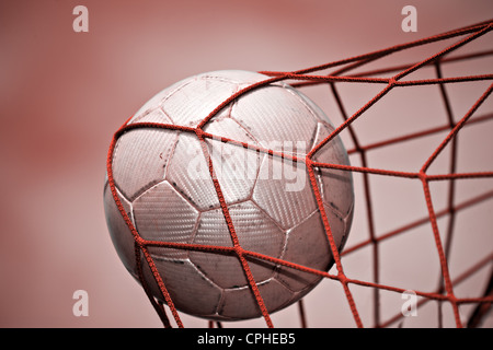 Image symbolique pour le but avec un ballon de soccer dans net Banque D'Images