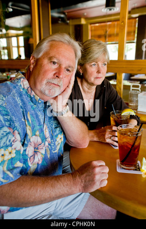 Un couple d'âge moyen semblait indifférent à l'ensemble plus de thés ensemble dans un Long Beach, CA, restaurant