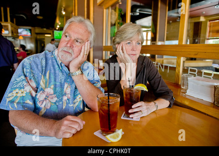 Un couple d'âge moyen semblait indifférent à l'ensemble plus de thés ensemble dans un Long Beach, CA, restaurant