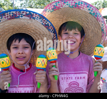 Mexican American garçons en jouant des maracas sombreros au défilé. Le jour de l'indépendance mexicaine Minneapolis Minnesota MN USA Banque D'Images