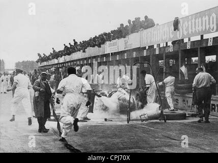 Grand Prix d'Allemagne au Nürburgring : opérations de lutte contre les incendies sur la voiture de von Brauchitsch, 1938 Banque D'Images