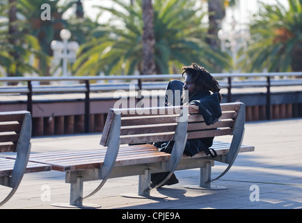 Barcelone, Espagne - Décembre 2011 : Rasta assis sur un banc. Banque D'Images