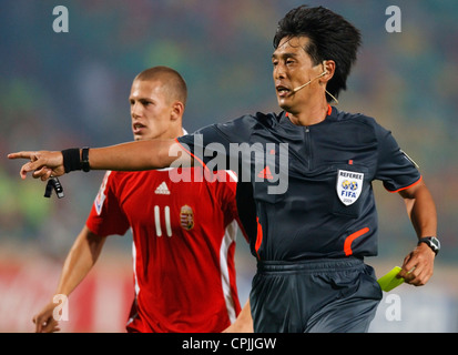 Arbitre Yuichi Nishimura (Japon) les gestes pour le point de penalty tout en tirant une carte jaune au cours d'une Coupe du Monde U-20 de la FIFA match Banque D'Images