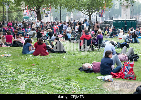 Les membres du public assis sur l'herbe en vert parc après le mariage du Prince William de Catherine Middleton. Banque D'Images