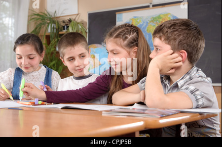 Quatre élèves âgés de 11 ans au desk in classroom Banque D'Images