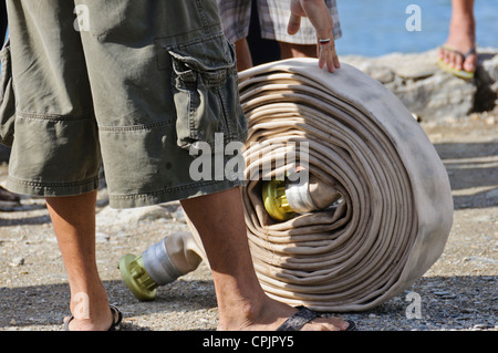 Rouleaux rouleau homme tuyau d'incendie matériel de lutte contre l'exercice d'incendie, Sabang, Puerto Galera, Mindoro oriental, Philippines, en Asie du sud-est Banque D'Images