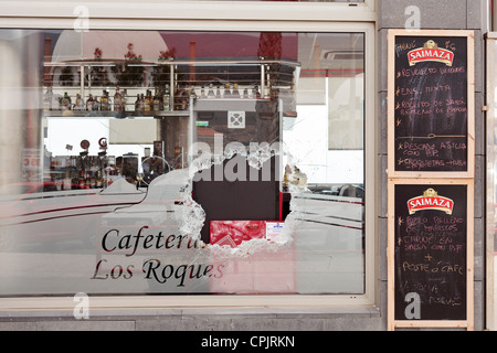 Fenêtre cassée lors d'une rupture dans un café où les voleurs ciblé la machine à sous. Des taches de sang sur la vitre. Los Roques Banque D'Images