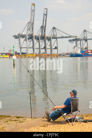 Un pêcheur se relâche par le port. Photographié au port de conteneurs international de Southampton, Hampshire, Angleterre, en mai 2012. Banque D'Images