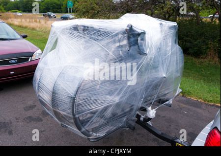 Vélos de route sur une voiture rack, enveloppée d'un film plastique comme protection contre la pluie. Banque D'Images