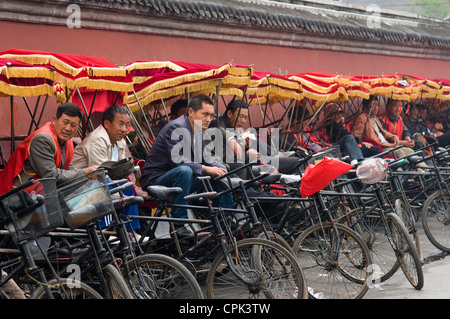 Les conducteurs de pousse-pousse en attente pour les clients près de la tour de la cloche à Beijing Chine Banque D'Images