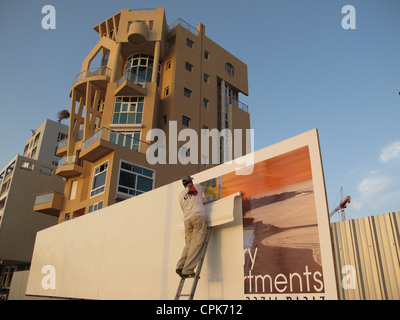 Un homme qui a mis en place un panneau publicitaire favorisant une construction d'un Nouveau bâtiment de luxe dans la rue Herbert Samual au bord de la mer De tel Aviv Israël Banque D'Images