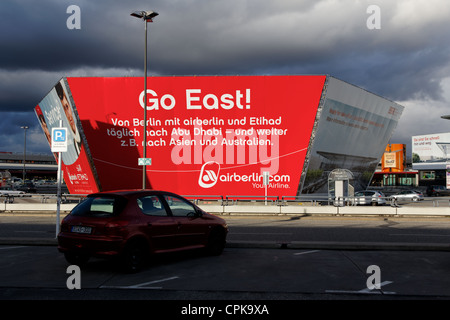 De sombres nuages planent sur une pièce lumineuse de publicité pour la sévère retard nouvel aéroport à vieux Berlin Tegel (TXL). Banque D'Images