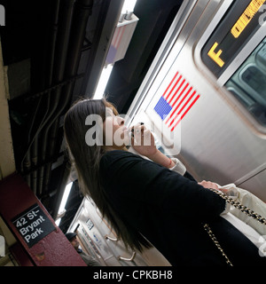 Une femme attend pour son train dans le métro à New York, Banque D'Images