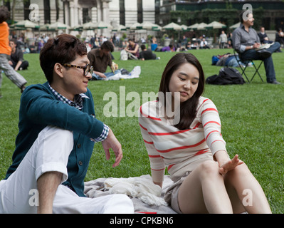 Un jeune homme et une femme passent du temps ensemble dans la région de Bryant Park à New York. Banque D'Images