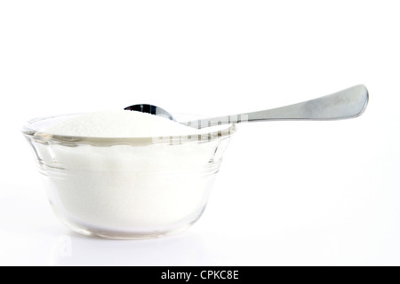 Sucre granulé sur fond blanc avec cuillère à café Banque D'Images