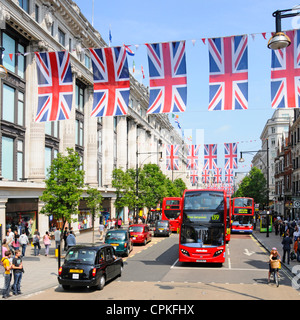 Black Cab et autobus dans Oxford Street en dehors de Selfridges avec Jubilé Union Jacks qui peuvent également être mises en place lors des Jeux Olympiques 2012 Banque D'Images