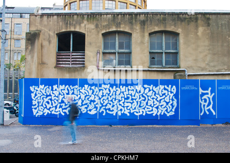 Un homme marchant passé graffiti dans South Bank, Londres Banque D'Images