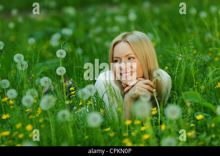 Fille avec un pissenlit dans sa main allongés sur l'herbe Banque D'Images