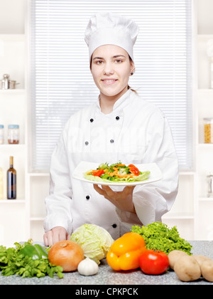 Jeune chef offrant des repas végétarien dans la cuisine Banque D'Images