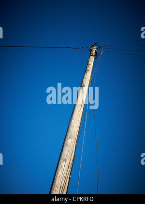 Poteau de téléphone avec des câbles isolés contre Deep blue sky au Royaume-Uni Banque D'Images