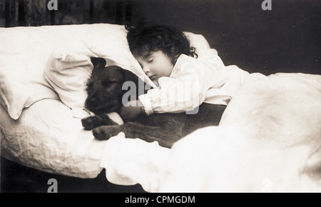 Little Girl Sleeping in bed with Puppy Banque D'Images