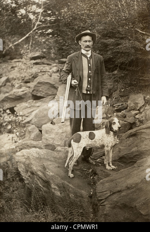 Hunter avec fusil de chasse dans les bois avec chien de chasse Banque D'Images