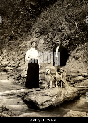 Couple bien habillé en pleine nature avec deux gros chiens Banque D'Images