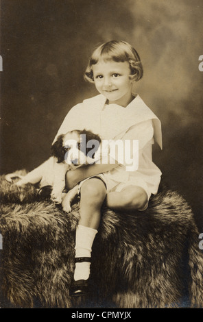 Happy Little Girl, berçant son chiot Banque D'Images