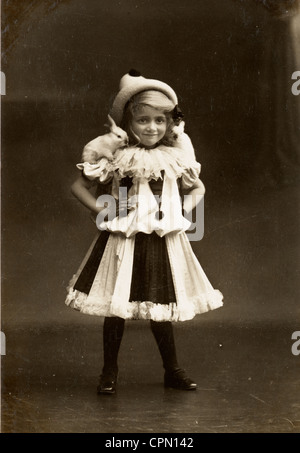 Petite fille en Costume Clown avec bébés lapins perchés sur ses épaules Banque D'Images