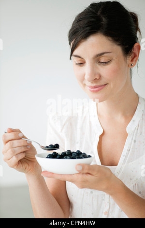 Woman eating bowl de bleuets frais Banque D'Images