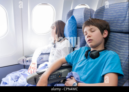 Les enfants dormant on airplane Banque D'Images