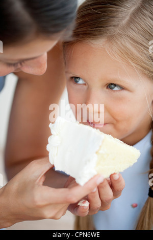 L'alimentation de la mère petite fille cake Banque D'Images