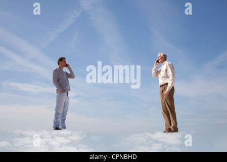 Hommes debout sur les nuages, l'utilisation de téléphones cellulaires Banque D'Images