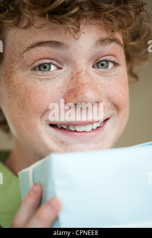 Preteen boy holding gift, portrait Banque D'Images