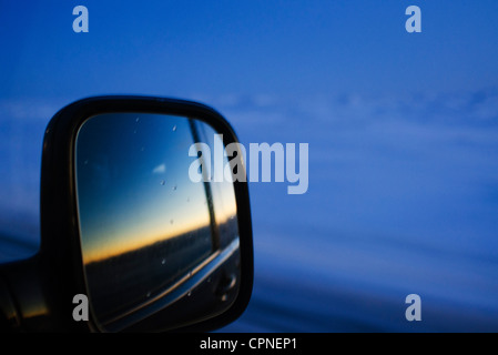 Coucher du soleil reflétée dans voiture rétroviseur Banque D'Images