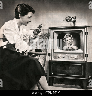 KOSS, Irene, 3.8.1928 - 2.5.1996, présentateur de télévision allemand, premier annonceur de télévision allemand après la guerre, 1950 - 1962 à NWDR, plus tard NDR, demi-longueur, en tant que spectateur devant un poste de télévision, un de ses collègues annonceur de télévision Angelika Feldmann est à l'écran, Allemagne, 1955, Banque D'Images