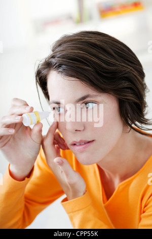 Femme à l'aide de Lotion oculaire Banque D'Images