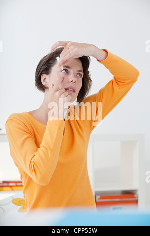 Femme à l'aide de Lotion oculaire Banque D'Images