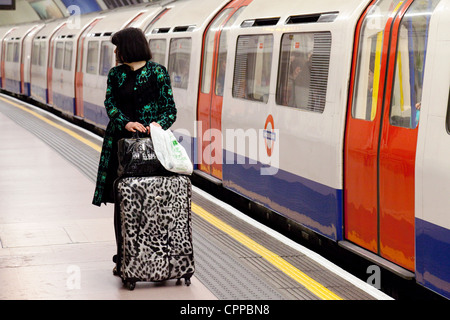 Une femme attraper une rame de métro, la gare de Kings Cross, London UK Banque D'Images