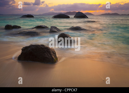 Virgin Gorda, îles Vierges britanniques, les Caraïbes de rochers à fleur d'eau dans les vagues de peu de Trunk Bay près de les thermes au coucher du soleil Banque D'Images