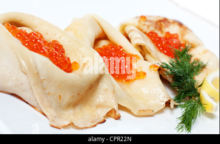 Petites crêpes avec du caviar rouge au milieu Banque D'Images