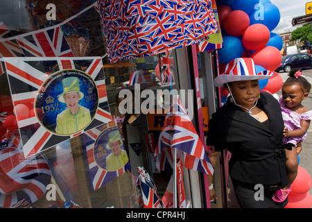 La mère et l'enfant avec patriotic bunting, drapeaux, ballons et royal souvenirs exposés avant le Jubilé de diamant de la Reine du sud de Londres dans une vitrine. Banque D'Images